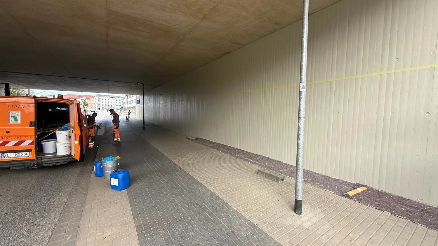Employees during concrete repair in an underpass in Rostock in front of already refinished concrete wall