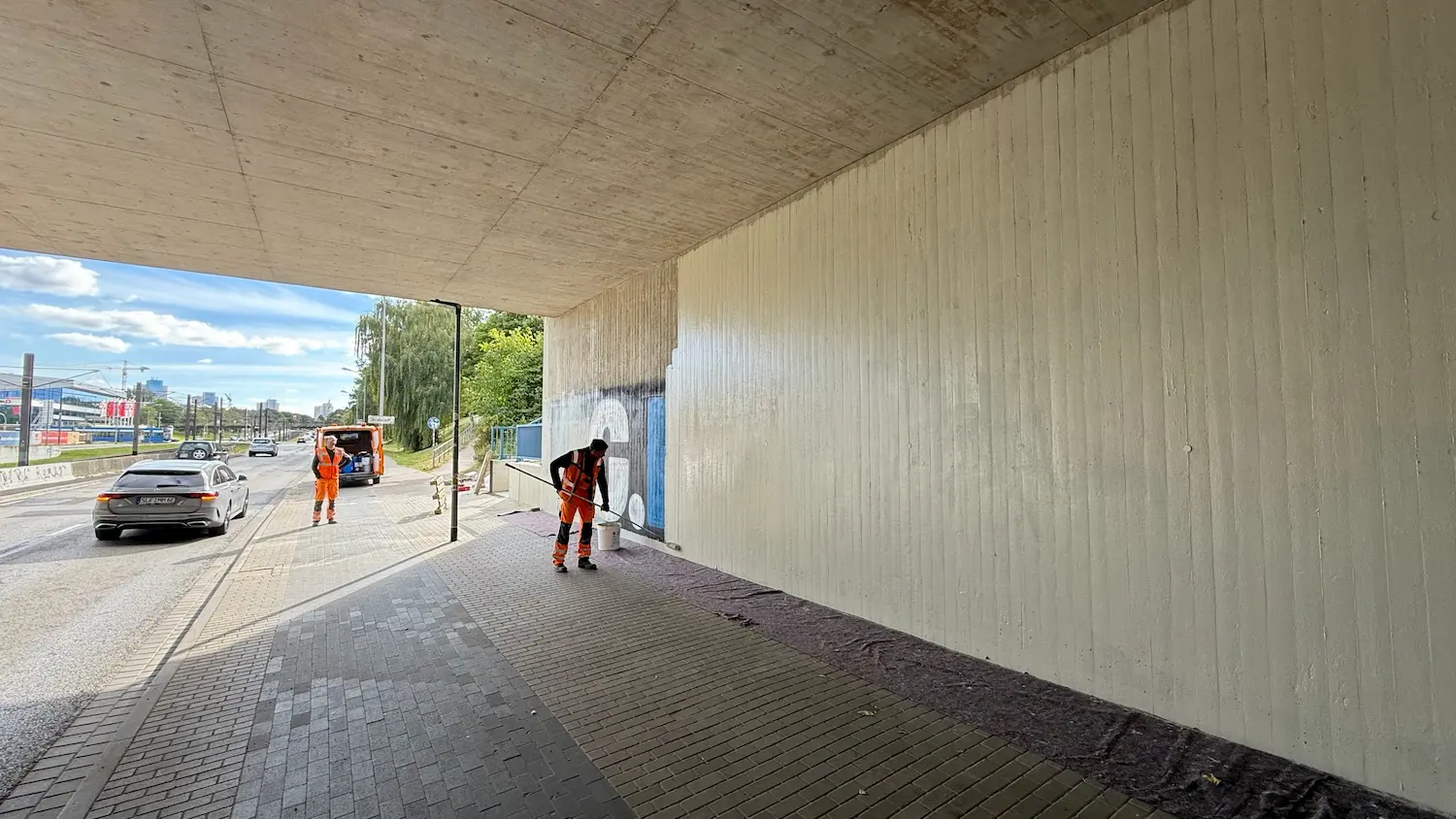 Employee refinishing a graffiti-affected concrete surface during concrete repair in Rostock