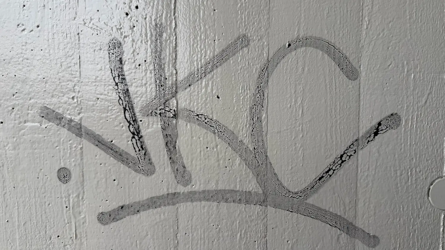 Detail of a graffiti trace on a refinished concrete surface in the Rostock reference project