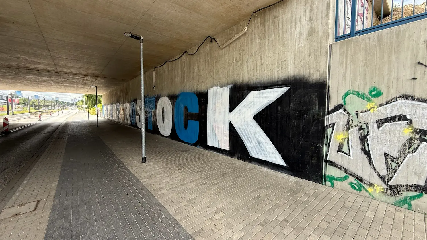 Concrete wall extensively covered with graffiti in an underpass in Rostock before concrete repair