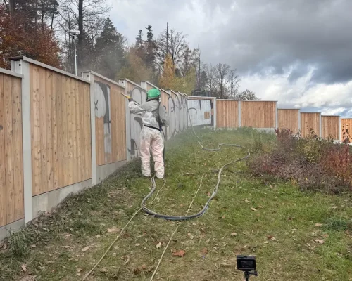 Mitarbeiter bei der Graffitientfernung an einer Lärmschutzwand mit Hochdrucktechnik